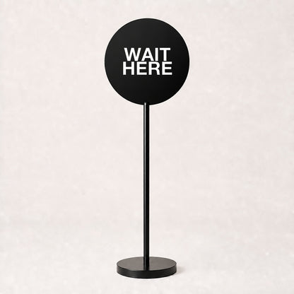 Black acrylic floor sign with WAIT HERE on the disc, example custom artwork