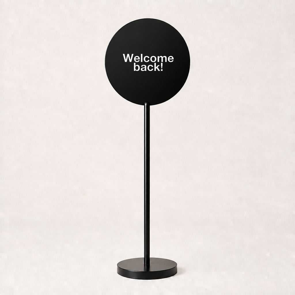 Black acrylic floor sign with Welcome back! on the disc, example custom artwork
