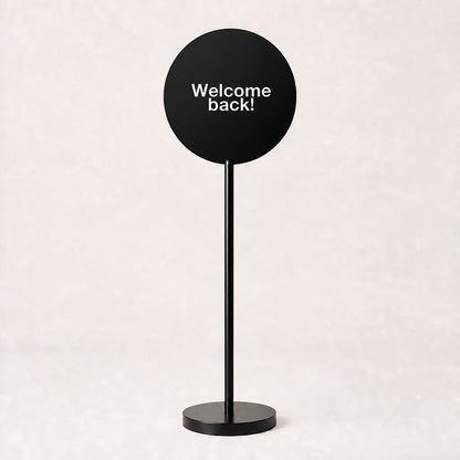 Black acrylic floor sign with Welcome back! on the disc, example custom artwork